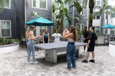 A group of residents playing ping pong in the courtyard